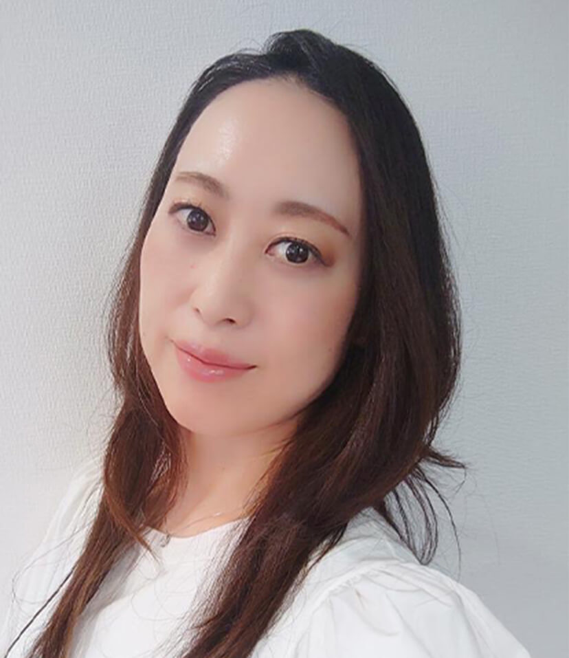 白い服を着たロングヘアの40代女性